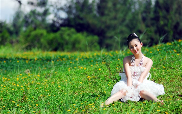亞洲女孩坐在草地上 桌布 圖片