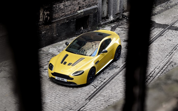 阿斯頓·馬丁V12 Vantage的黃色的超級跑車停在街頭 桌布 圖片