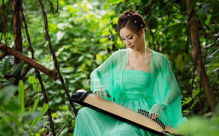 綠色禮服的亞洲女孩彈古箏 桌布 圖片