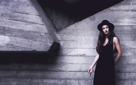 黑色連衣裙的女孩，帽子，牆