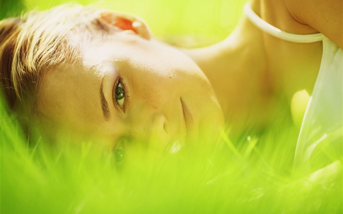 女孩躺在草叢中，綠色 桌布 圖片