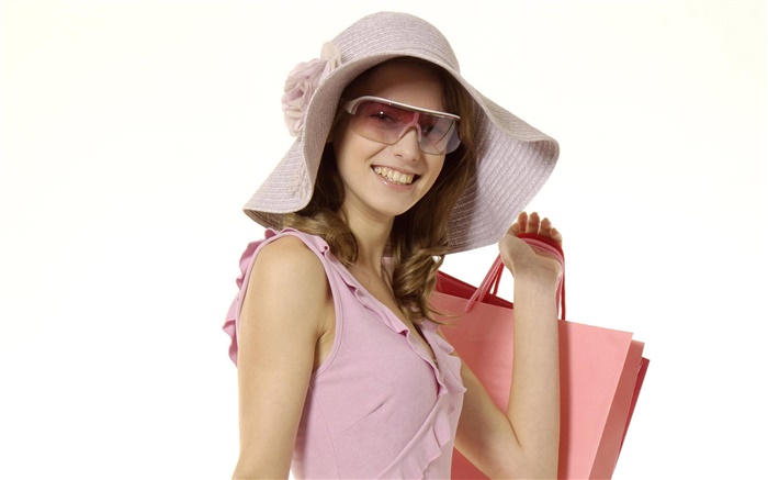 快樂購物的女孩，粉紅色的衣服，帽子，太陽鏡 桌布 圖片