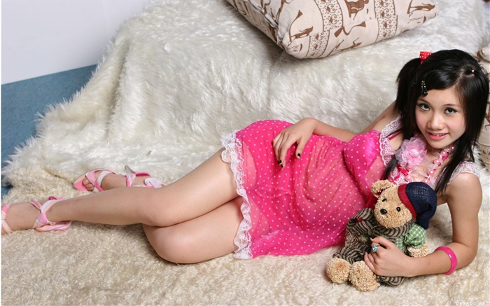 微笑粉紅色連衣裙的亞洲女孩，床，玩具 桌布 圖片