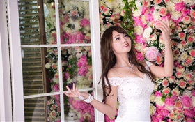 微笑亞洲女孩，白色禮服，鮮花背景