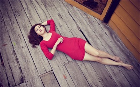亞洲女孩趴在木地板，紅色禮服