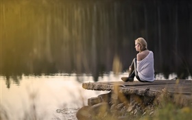 女孩坐在湖邊